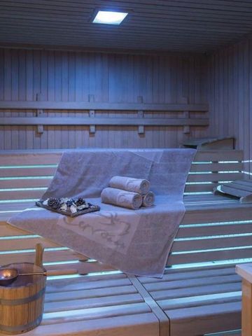 Sauna aus Holz mit Handtüchern und Eimer.