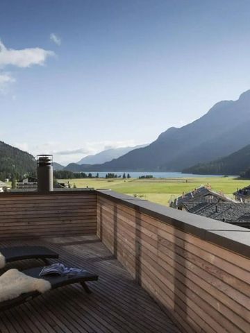 Sonnige Terrasse mit Liegestühlen und Panorama-Blick auf Berge und Tal.