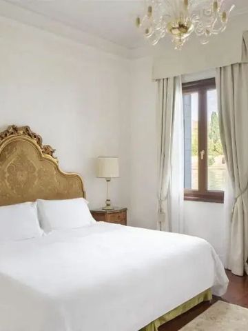 Lichtdurchflutetes Schlafzimmer mit luxuriösem Bett und goldener Kopfteilverzierung