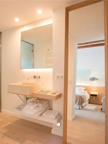 Offenes Badezimmerdesign mit Blick auf das Schlafzimmer durch eine Glastür.