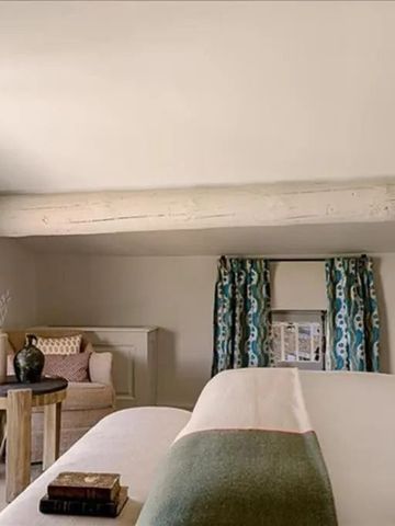 Zimmer mit hellem Dekor und sichtbaren Holzbalken