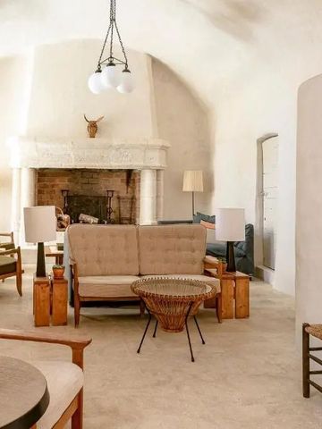 Gemütlich eingerichtete Lounge mit Kamin in weißem Raum.