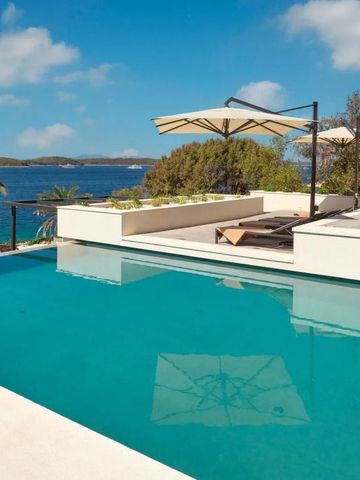 Infinity Pool mit Meerblick und Sonnenliegen unter Sonnenschirmen