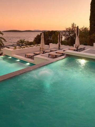 Beleuchteter Pool bei Sonnenuntergang mit Meer- und Landschaftsblick