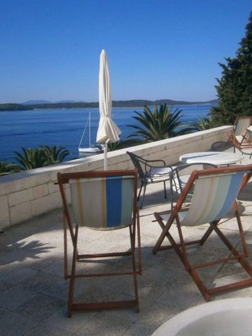 Terrasse mit Liegestühlen und Blick auf das blaue Meer