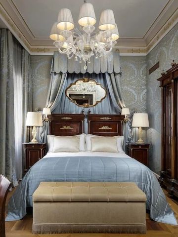 Elegantes Schlafzimmer mit luxuriösem Bett und klassischer Dekoration in Blau und Silber