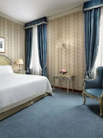 Elegantes Hotelzimmer mit blauen Akzenten und klassischen Möbeln