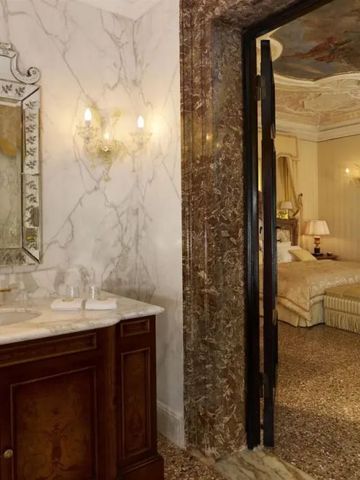 Luxuriöses Badezimmer mit Marmordetails und Blick ins Schlafzimmer