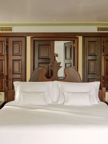 Geräumiges Schlafzimmer mit edler Holzausstattung und großer Bettanlage