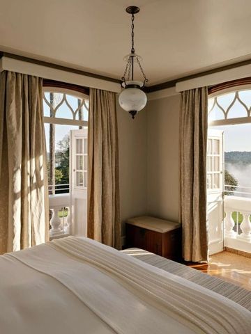 Elegantes Hotelzimmer mit Blick auf Wasserfall durch offene Türen