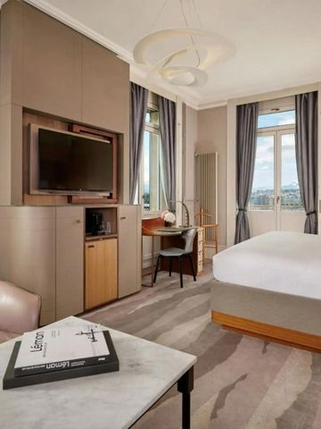 Modern eingerichtetes Hotelzimmer mit großen Fenstern und Sitzbereich