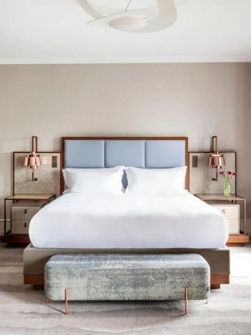 Elegantes Hotelzimmer mit modernem Design und großen Fenstern sowie weißer Bettwäsche