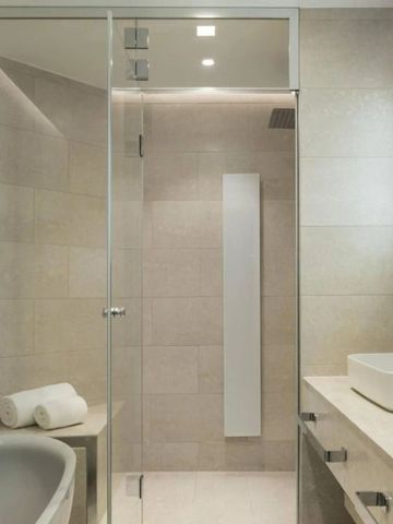 Modernes Badezimmer mit Dusche, edlem Waschbecken und hochwertigen Materialien