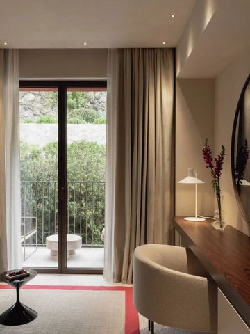 Hotelzimmer mit Balkon und stilvoller Einrichtung, dezente Beleuchtung