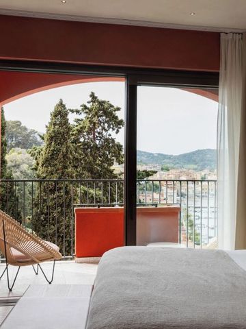 Helles Hotelzimmer mit Blick auf Balkon und malerische Landschaft