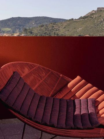 Sonnenliege mit Kissen auf Terrasse mit Bergblick
