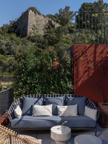 Gemütliche Terrasse mit Sofa und Blick auf Natur und Ruine
