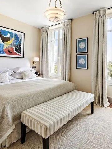 Elegantes Schlafzimmer mit Kunst an den Wänden und Doppelbetten