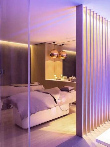 Modernes Spa-Zimmer mit entspannender Beleuchtung und Massageliegen