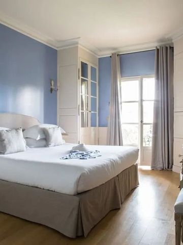 Helles Hotelzimmer mit Kingsize-Bett und blauer Akzentwand