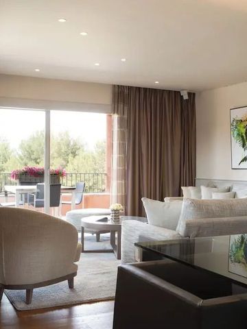 Geräumiges Wohnzimmer einer Suite mit stilvoller Einrichtung und Balkonblick