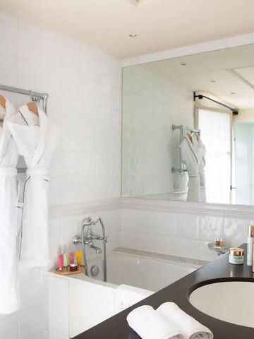 Elegantes Badezimmer mit Badewanne und großen Spiegeln im Hotel