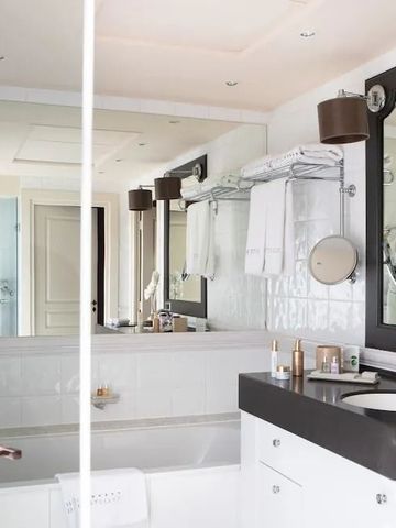 Modernes Badezimmer mit eleganter Einrichtung und großem Spiegel.