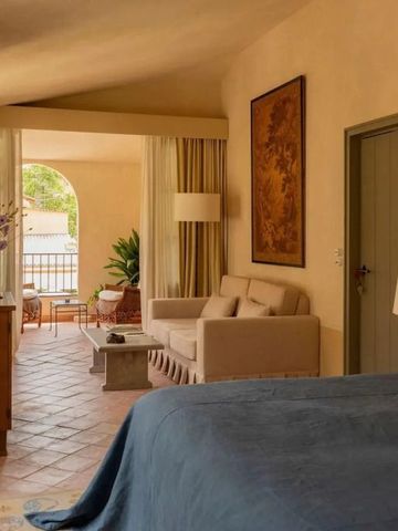 Elegantes Hotelzimmer mit gemütlicher Sitzecke und Blick auf den Balkon.