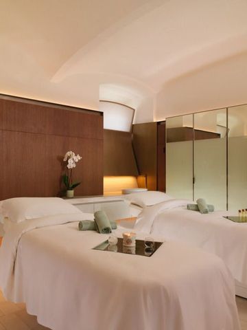 Entspannungsraum im Spa mit zwei Massageliegen und sanfter Beleuchtung.