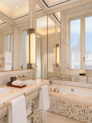 Geräumiges Badezimmer mit Spiegeltüren und Marmorbadewanne.