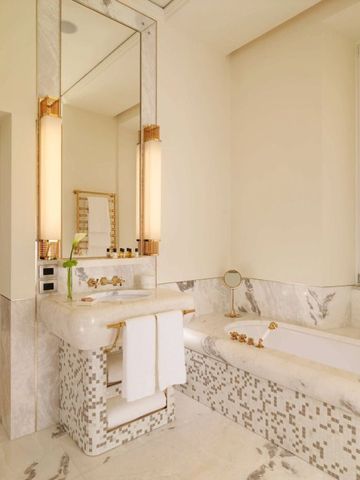 Modernes Badezimmer mit Marmorakzenten und eleganten Leuchten.