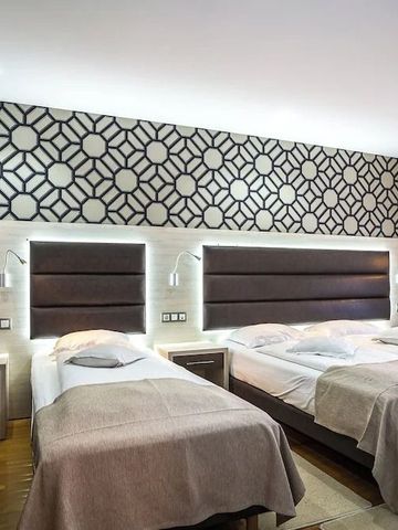 Hotelzimmer mit zwei Doppelbetten und dekorativer Wandgestaltung