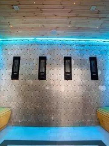 Moderne Sauna mit buntem LED-Licht und Holzsitzbänken