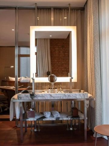 Luxuriöses Badezimmer mit beleuchtetem Spiegel und Marmorwaschbecken