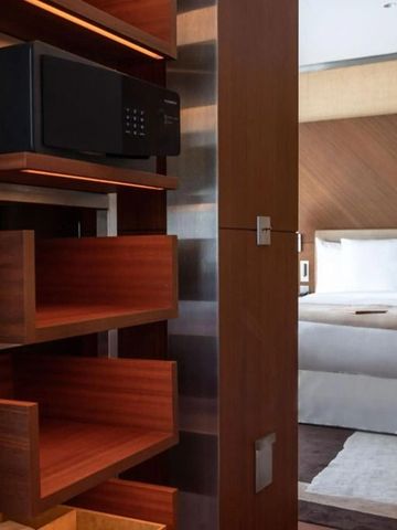 Edles Hotelzimmer mit luxuriösem Doppelbett und offenem Schrankbereich