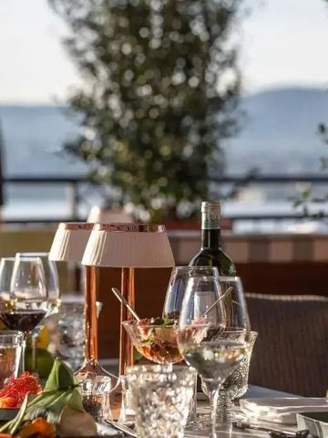 Luxuriös gedeckter Tisch auf einer Terrasse mit Blick auf den See