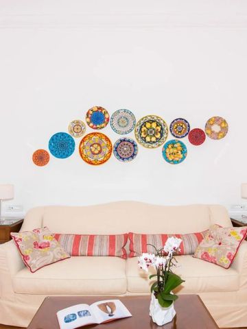 Gemütliches Wohnzimmer mit farbenfroher Wanddekoration und bequemer Couch