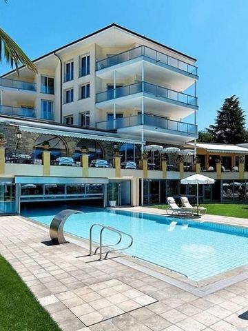 Hotelgebäude mit Balkonen und Außenpool bei sonnigem Wetter