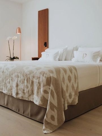 Doppelbett in Es Príncep Hotel mit eleganter Bettwäsche.