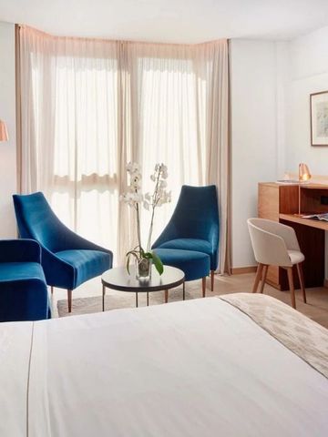 Elegantes Hotelzimmer mit Sitzbereich und Schreibtisch.
