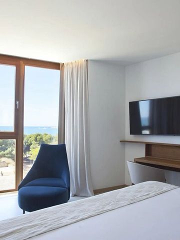 Helles Hotelzimmer mit großem Fenster und Blick auf die Landschaft