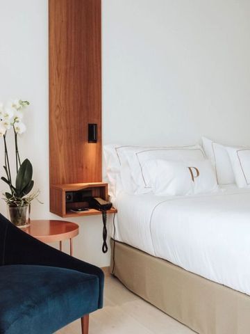 Modernes Hotelzimmer mit Doppelbett und eleganten Holzakzenten