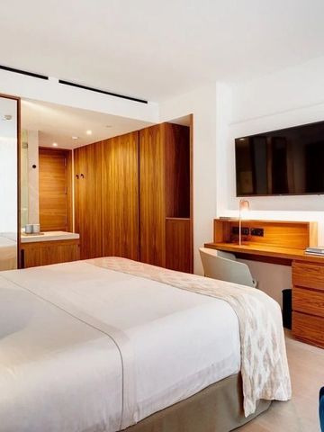 Schickes Hotelzimmer mit großem Spiegel und Fernseher an der Wand