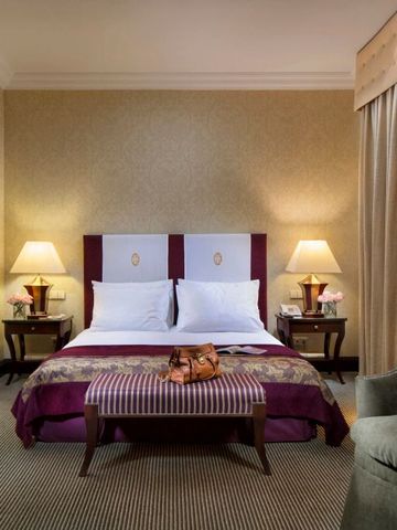 Luxuriöses Doppelzimmer mit gedeckten Farben und Leselampen