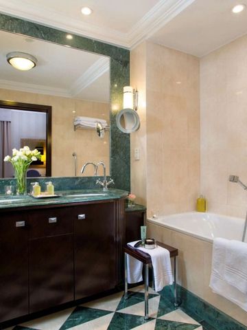 Badezimmer mit Marmordekor und großzügiger Badewanne