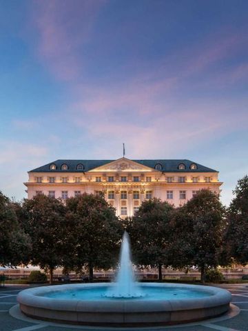 Prachtvolle Fassade des Hotel Esplanade Zagreb bei Sonnenuntergang mit Brunnen im Vordergrund.