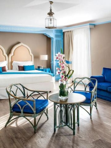 Helles, geräumiges Zimmer mit blauem Sofa und getäfelten Wänden im Hotel Excelsior Venice.