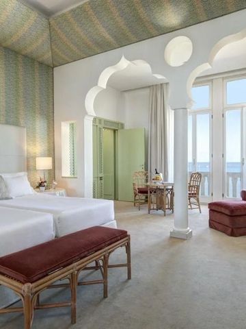 Elegantes Hotelzimmer mit Balkon und Meerblick, einladende Einrichtung