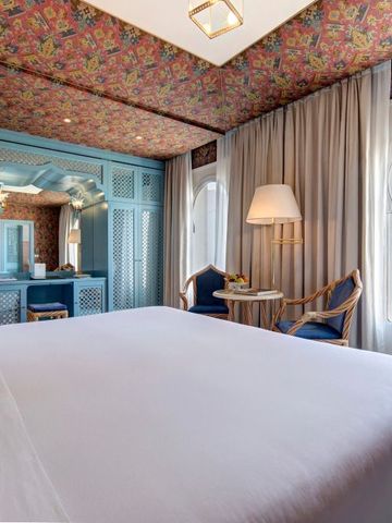 Luxuriöses Schlafzimmer im Hotel mit floralem Dekor und großen Fenstern