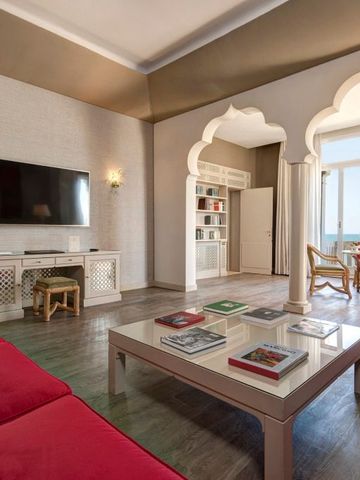 Geräumiges Wohnzimmer einer Suite mit roten Sofas und Meerblick